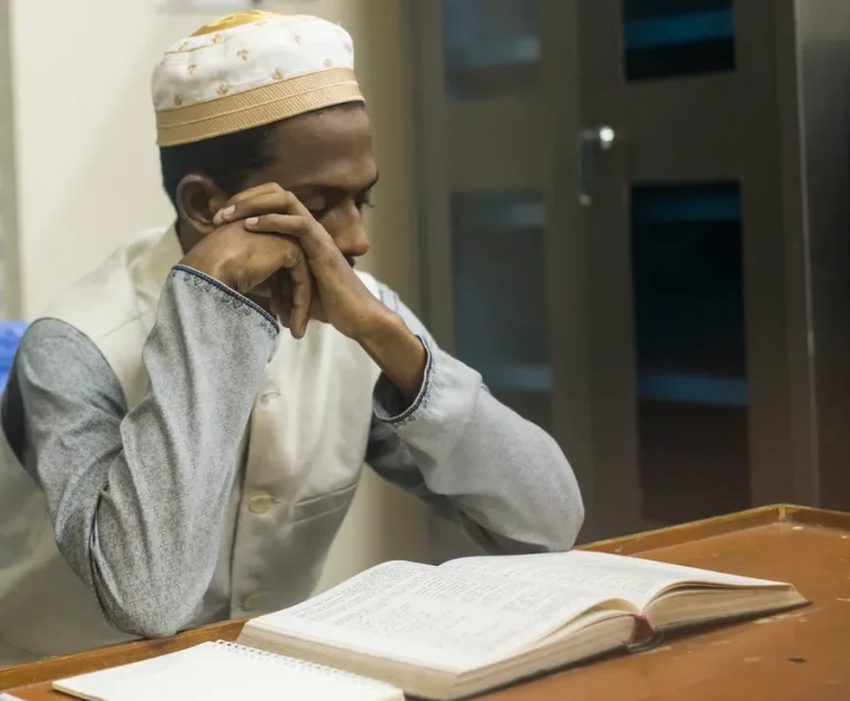 Adult man studying the Quran at a desk