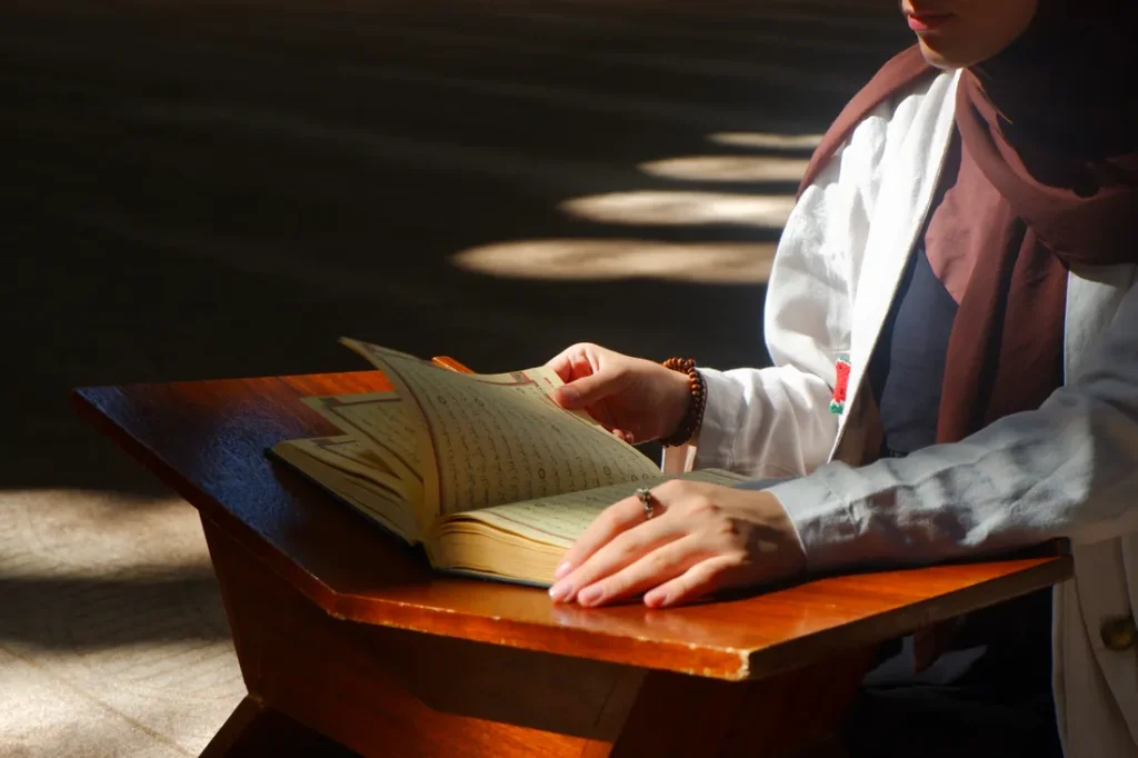 Woman reading the Quran on a wooden stand