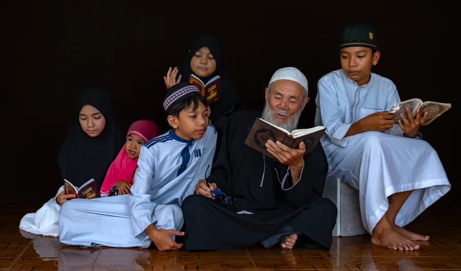 Grandfather reading the Quran with his grandchildren