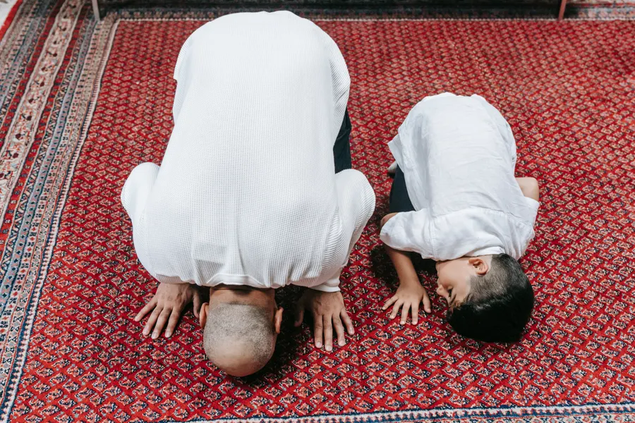 Father and son praying Salah side by side