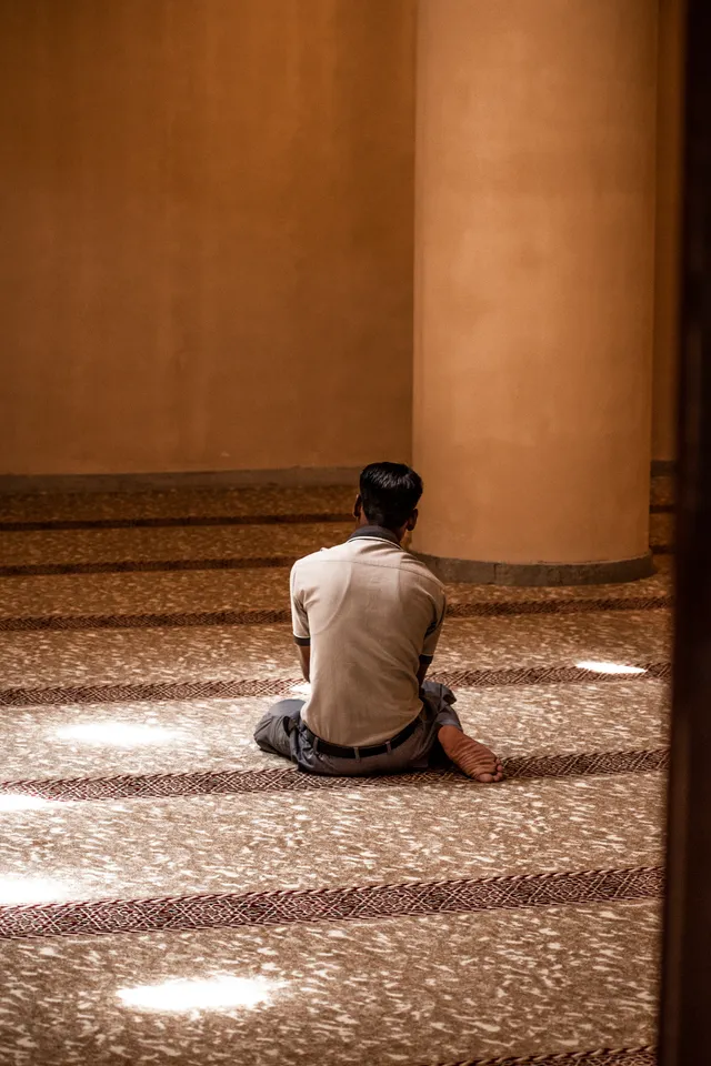 Man sitting in prayer in a mosque