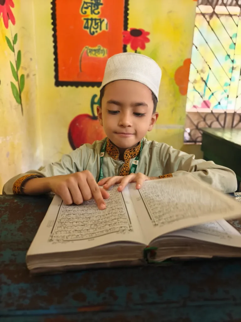 Child following Arabic text with his finger