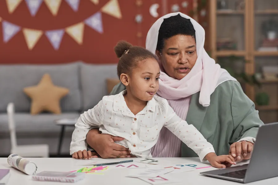 Mother and daughter joining an online class on a laptop