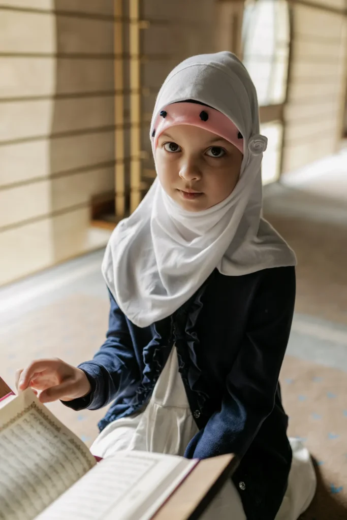 Girl in a hijab reading the Quran