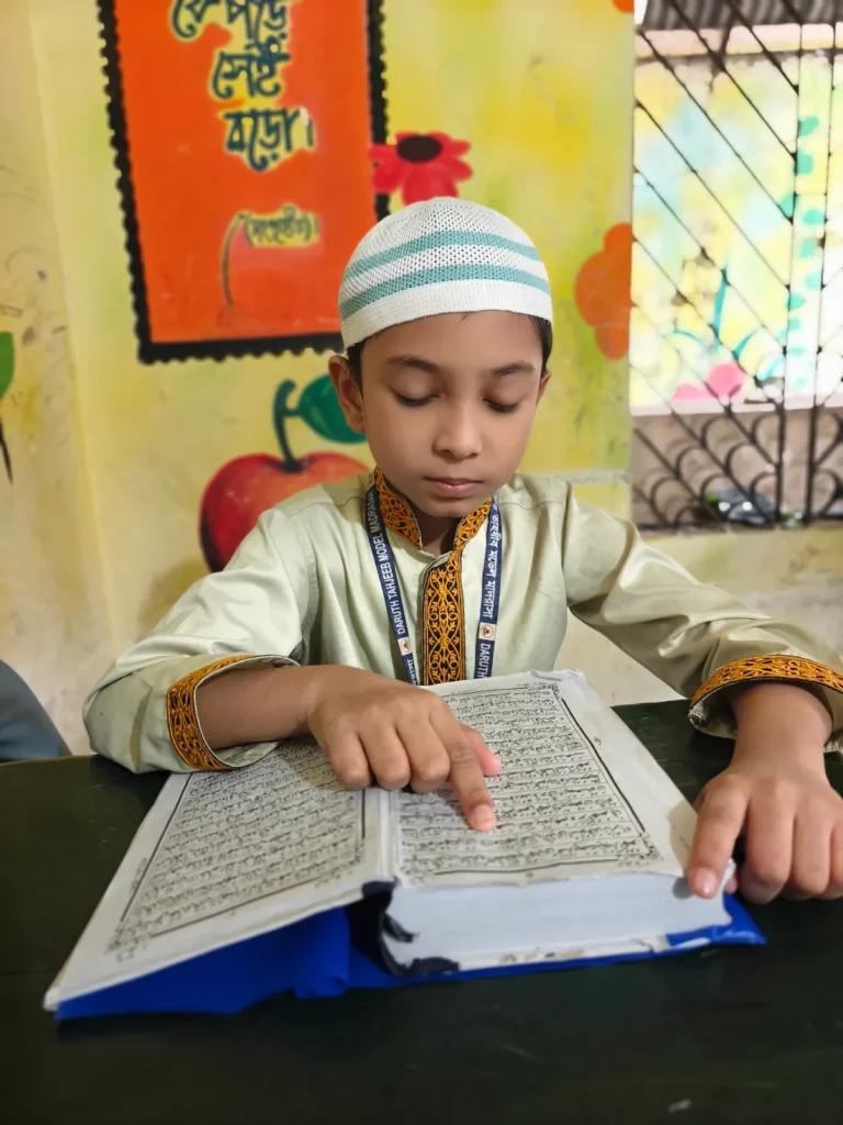 Boy reading the Quran at his desk