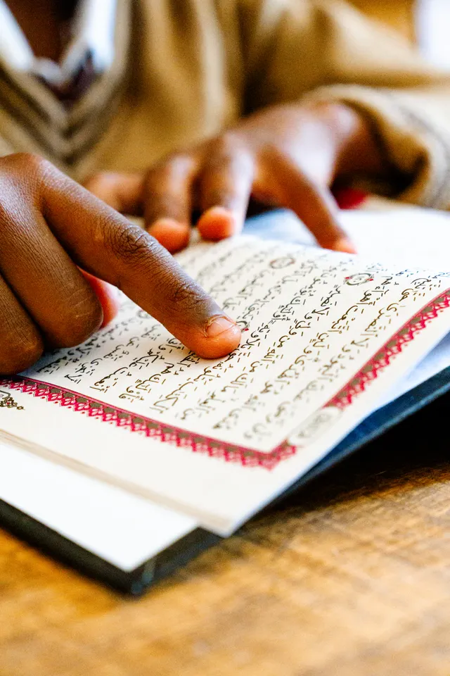 Beginner pointing to each word while reading the Quran