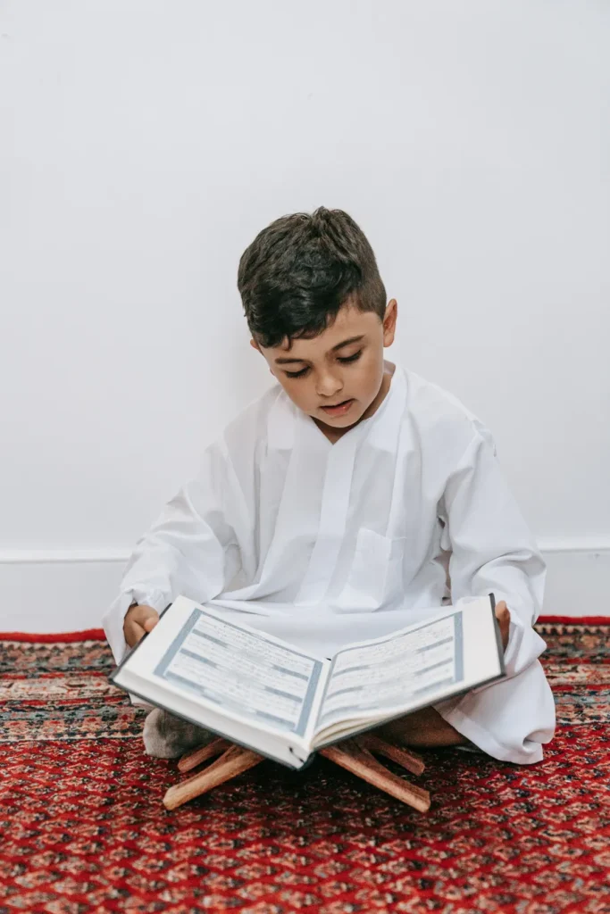 Young boy reading the Quran to memorize it