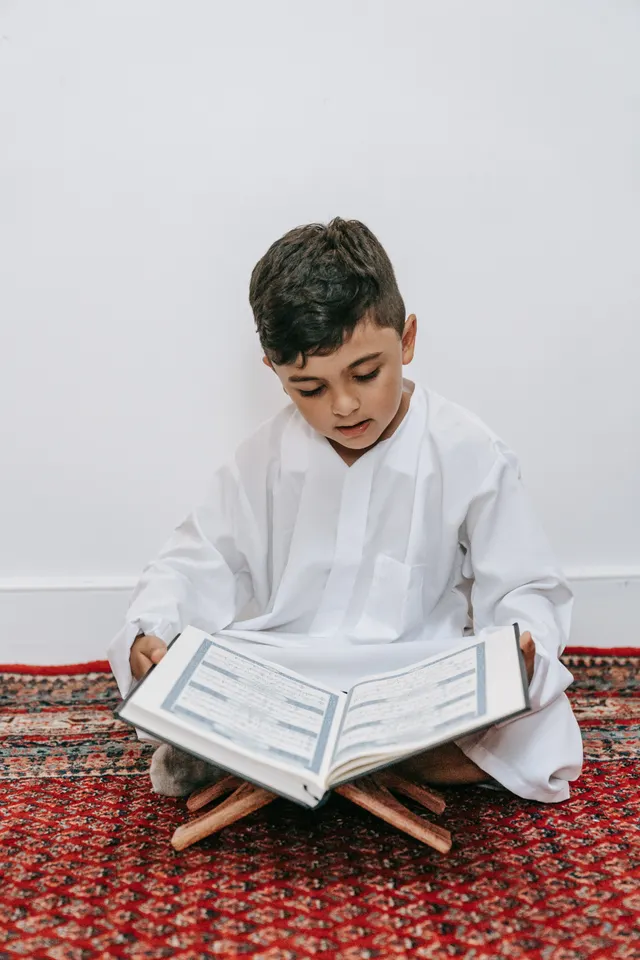 Young boy reading the Quran to memorize it
