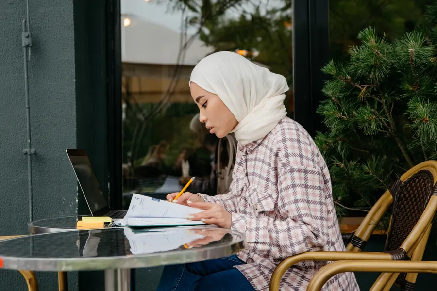 Woman in a hijab writing study notes